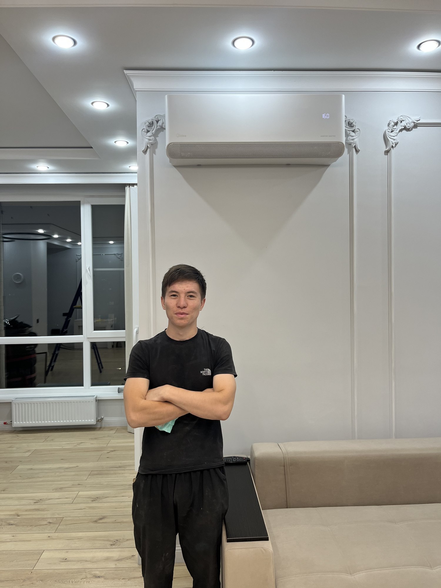 Специалист рядом с установленным кондиционером